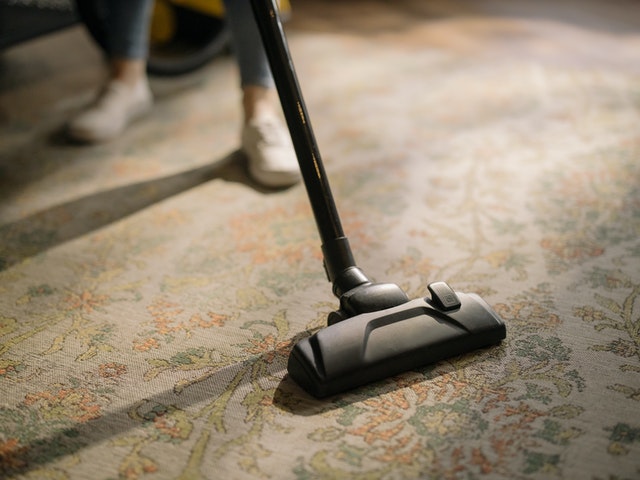A person vacuuming a carpet.